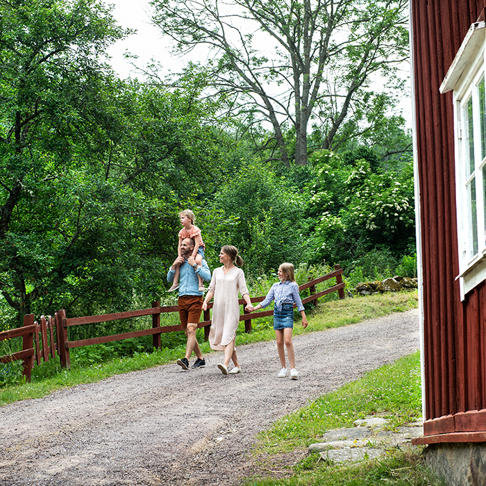 Familj går på grusväg i Småland
