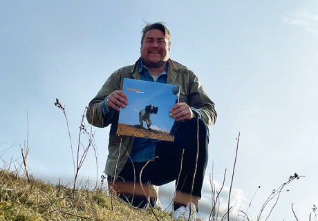 Glad man håller i skiva med en hund på