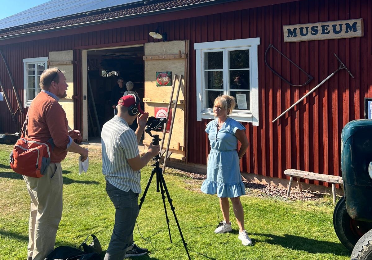 Carina Nors blir intervjuad framför ett museum i Bälaryd