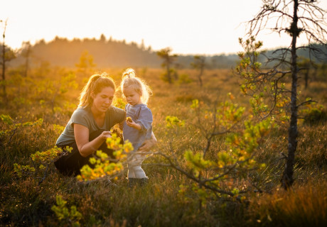 En mamma och dotter som utforskar naturen tillsammans i soluppgång på Store mosse.